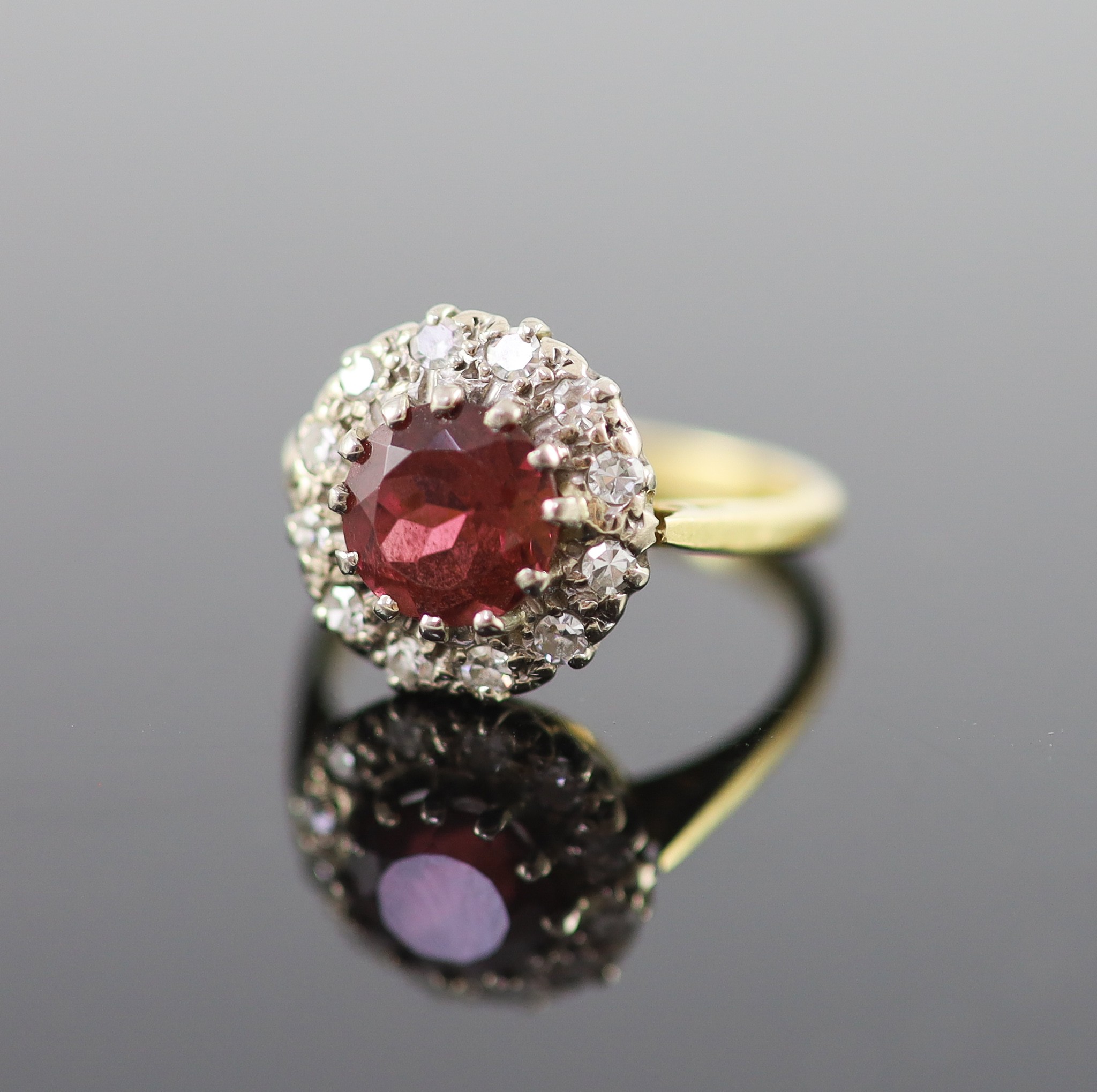 A modern 18ct gold, deep pink tourmaline and diamond set oval cluster ring